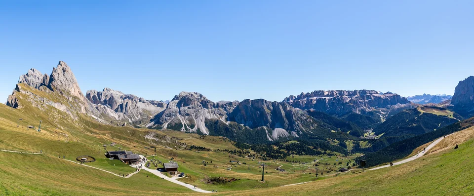 Panoramic view of green alpine meadows and jagged Dolomite peaks seen from Seceda in Val Gardena, South Tyrol, Italy