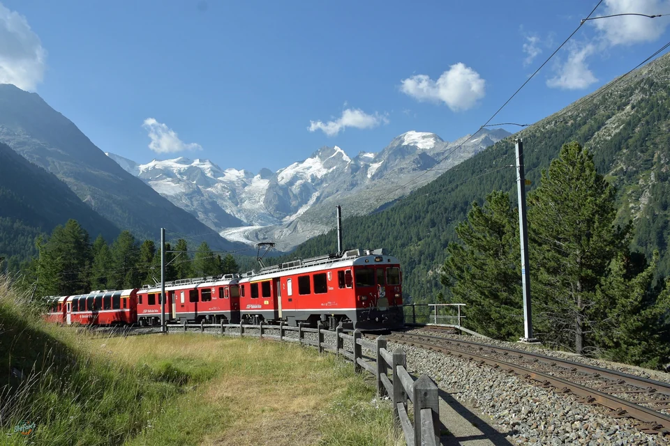 Red Bernina Express train curving through the Montebello bend near Pontresina, Swiss Alps