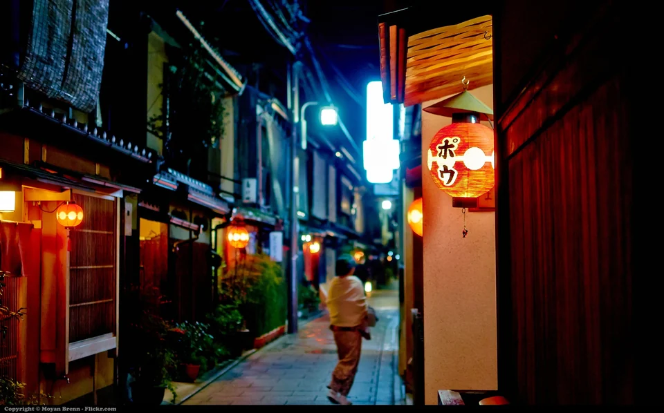 Narrow stone-paved alley with wooden townhouses and lanterns in the Gion district of Kyoto, Japan, at dusk