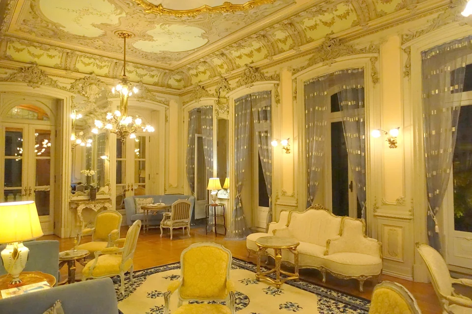 Ornate gilded salon with painted ceiling inside the Pestana Palace hotel in Lisbon