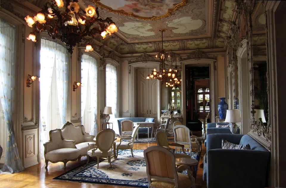 Lounge with blue sofas, period chairs and chandeliers in the historic palace at Pestana Palace Lisboa