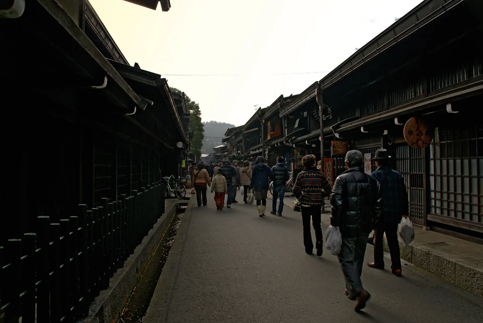 Dark wooden Edo-period merchant houses lining a street in the Sanmachi district of Takayama