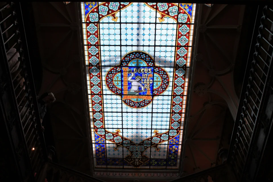 Geschwungene rote Treppe und geschnitzte Holzdecke in der Buchhandlung Livraria Lello in Porto