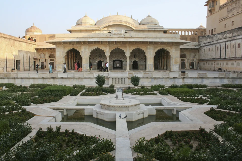 Goldgelbe Wälle und Tore des Amber Fort, die an einem Hang über dem Maota-See bei Jaipur emporsteigen