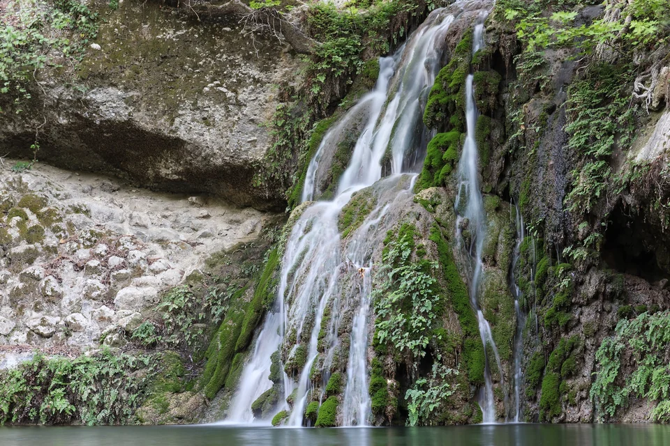 Small waterfall and stream surrounded by trees in the Petaloudes Valley of the Butterflies, Rhodes