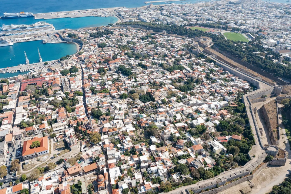 Aerial view of the medieval city walls and moat of Rhodes Old Town with the town and harbor beyond