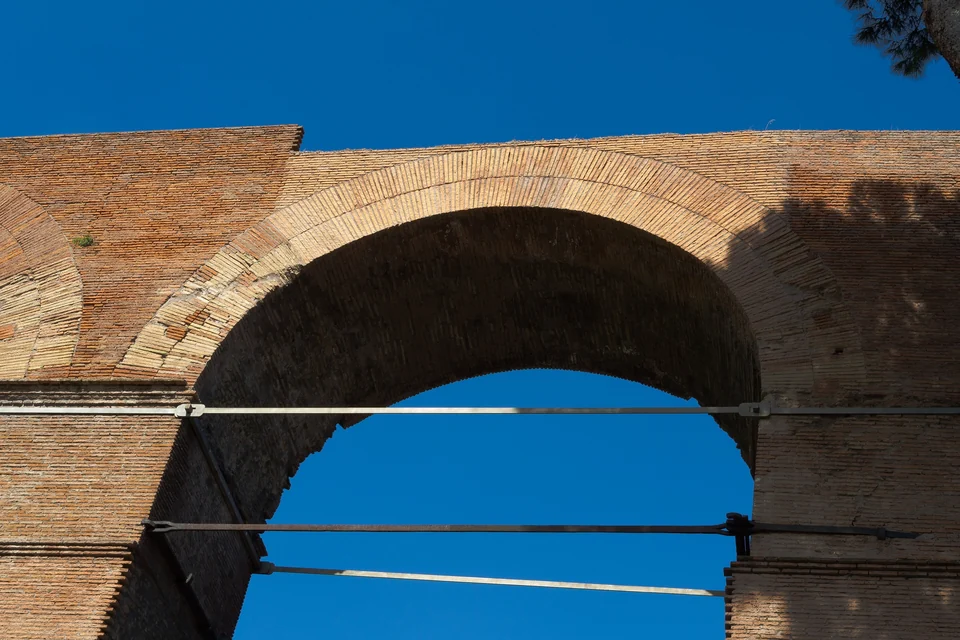 Columns and ruined temples of the Roman Forum in Rome seen from above under a blue sky