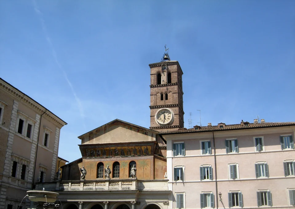 The facade and bell tower of Santa Maria in Trastevere basilica on a square in Rome