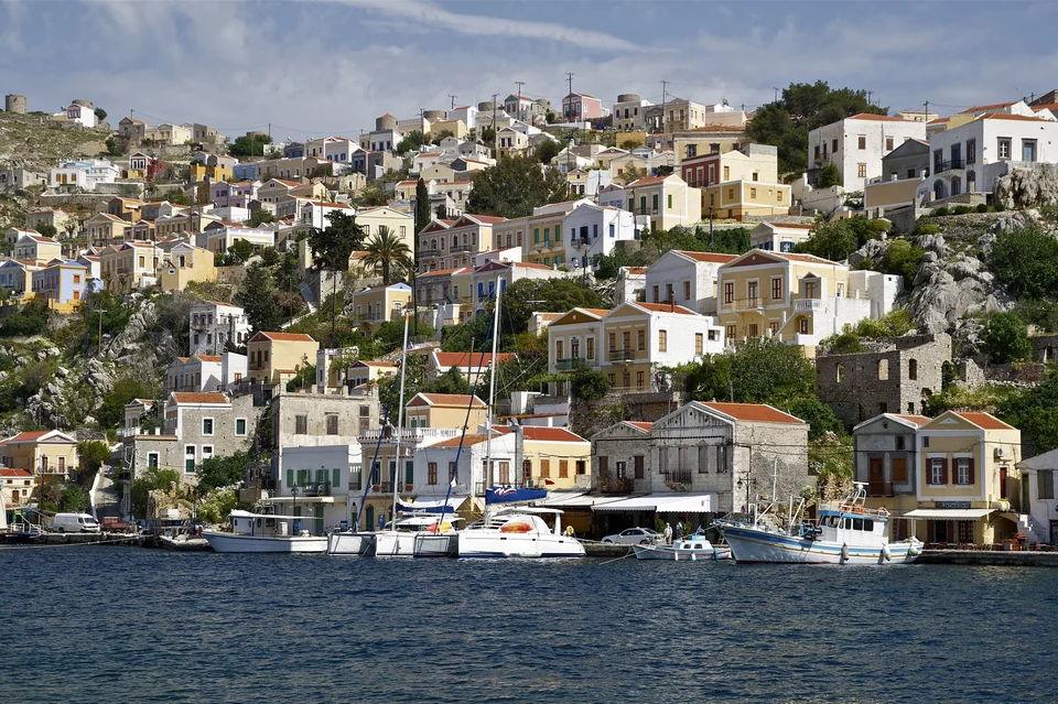 Colorful neoclassical houses rising above the harbor of Symi island in the Dodecanese, Greece