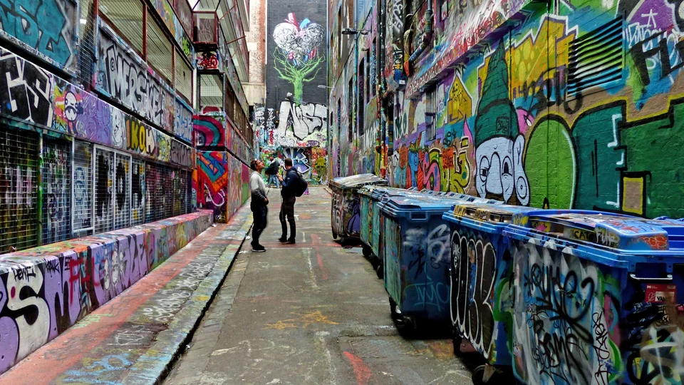 Colorful graffiti and street art covering the walls and bins of Hosier Lane in central Melbourne