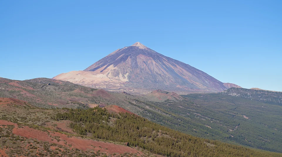Pico del Teide rising above green slopes and clouds on Tenerife in the Canary Islands