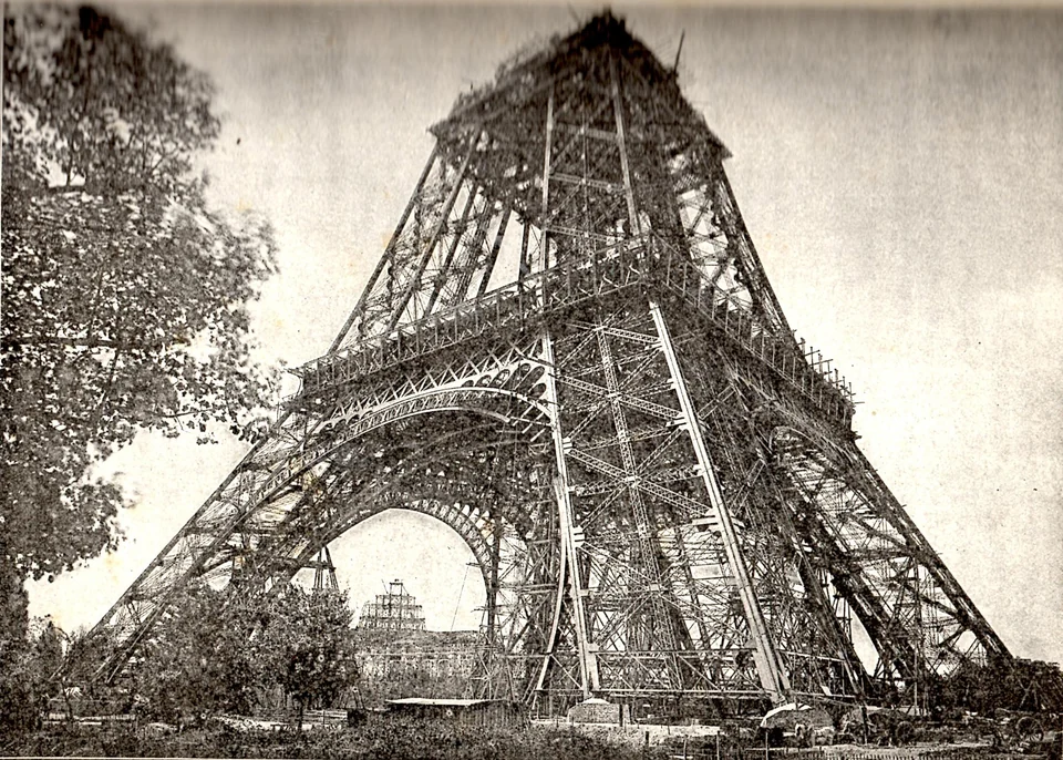 Black and white photo of the unfinished Eiffel Tower in July 1888 with scaffolding above the second level