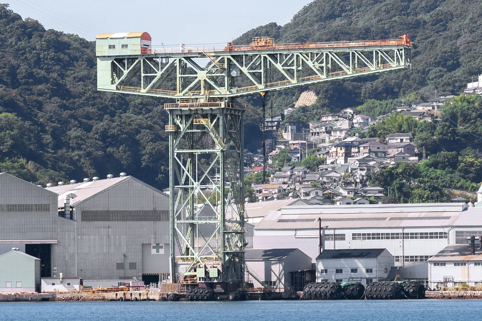 Green Giant Cantilever Crane at the Mitsubishi shipyard on Nagasaki harbor with wooded hills behind