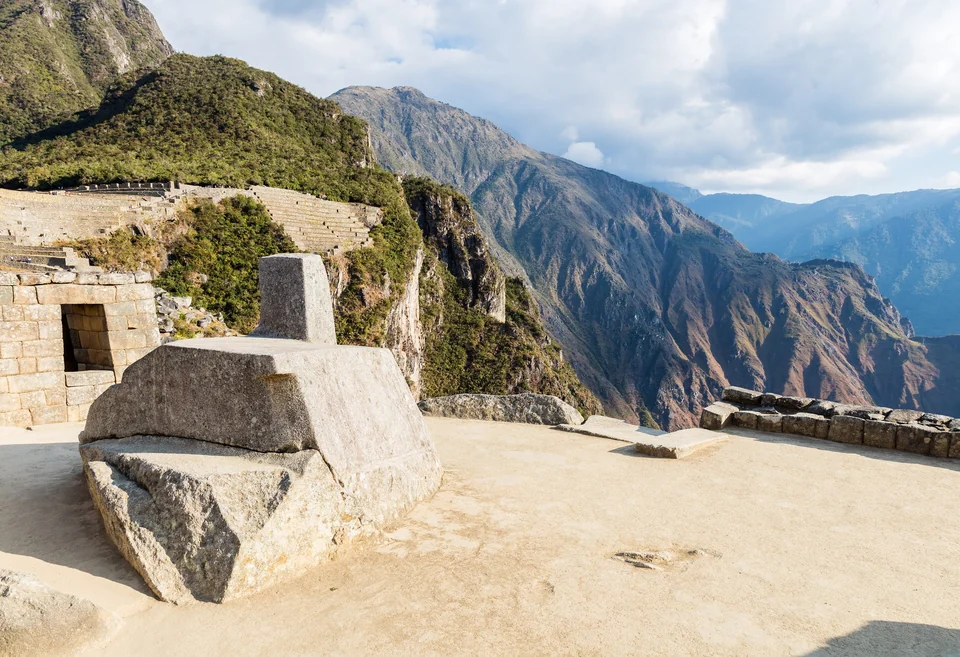Panoramic view of the Machu Picchu citadel with terraces and stone buildings below Huayna Picchu peak in Peru