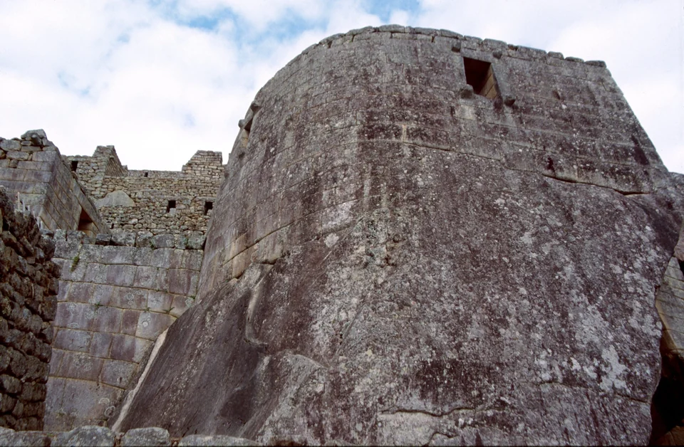Curved ashlar stone wall of the Temple of the Sun (Torreón) at Machu Picchu built over a natural rock