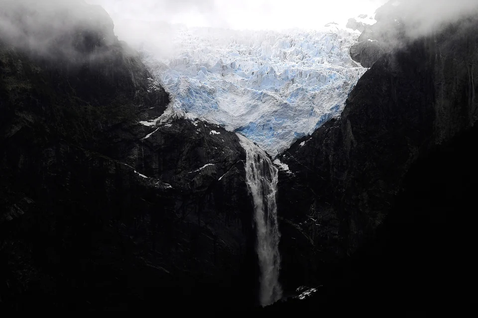 Der Hängegletscher von Queulat thront über einer Klippe mit einem langen Wasserfall im Nationalpark Queulat, Chile.