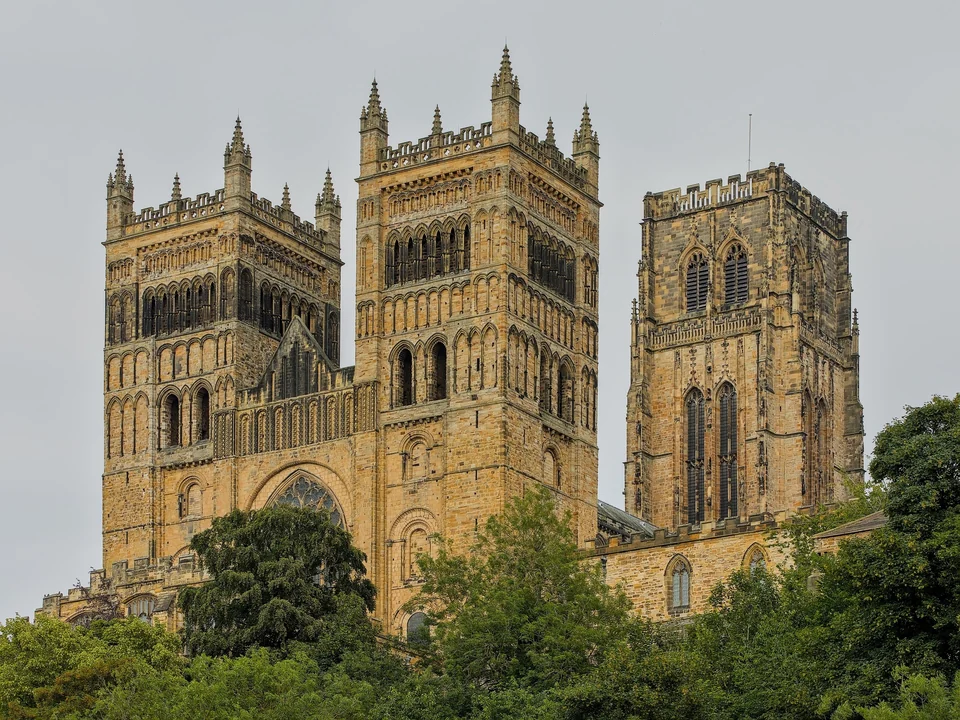 Durham Cathedral rising above trees on the bank of the River Wear in Durham, England