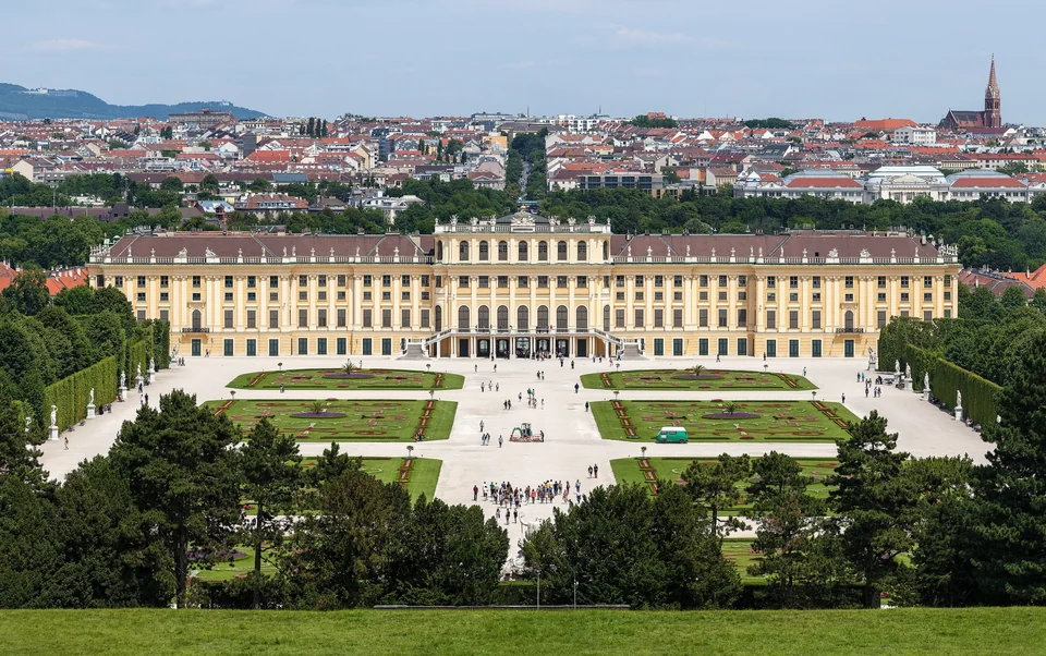 The long yellow facade of Schönbrunn Palace in Vienna across its grounds