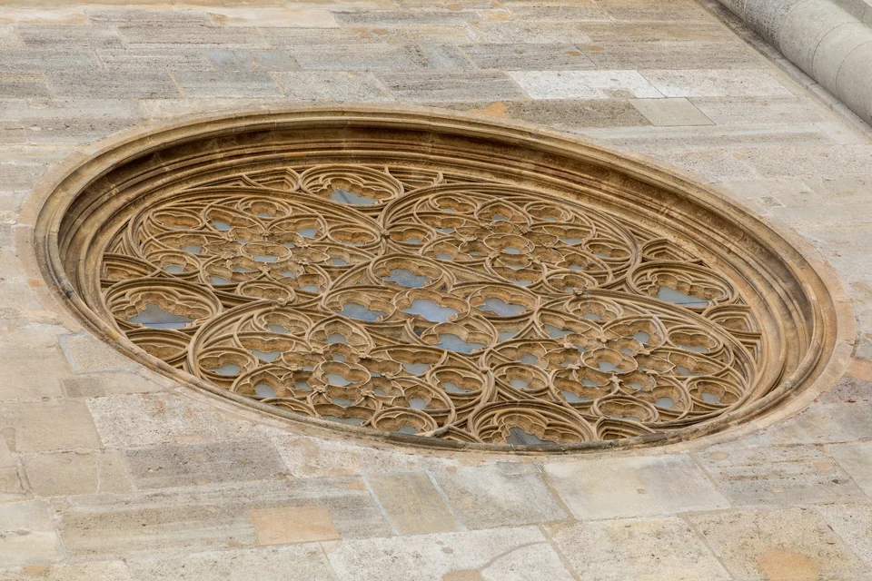 Gothic stone tracery in a large oval window on the exterior of St Stephen's Cathedral in Vienna