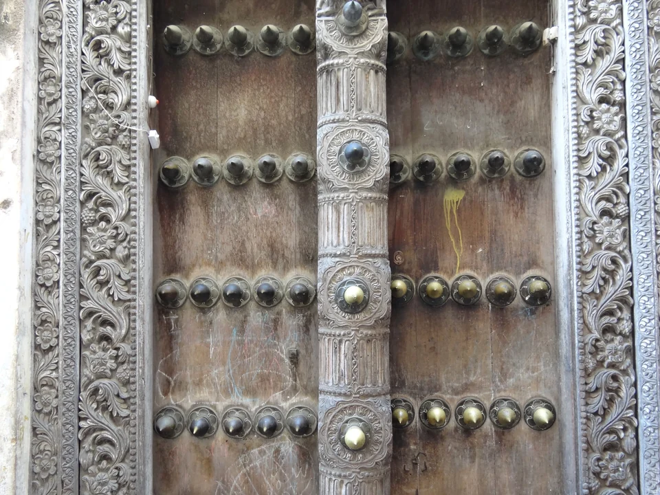 Detail einer kunstvoll geschnitzten Holztür mit Messingnieten in Stone Town, Sansibar