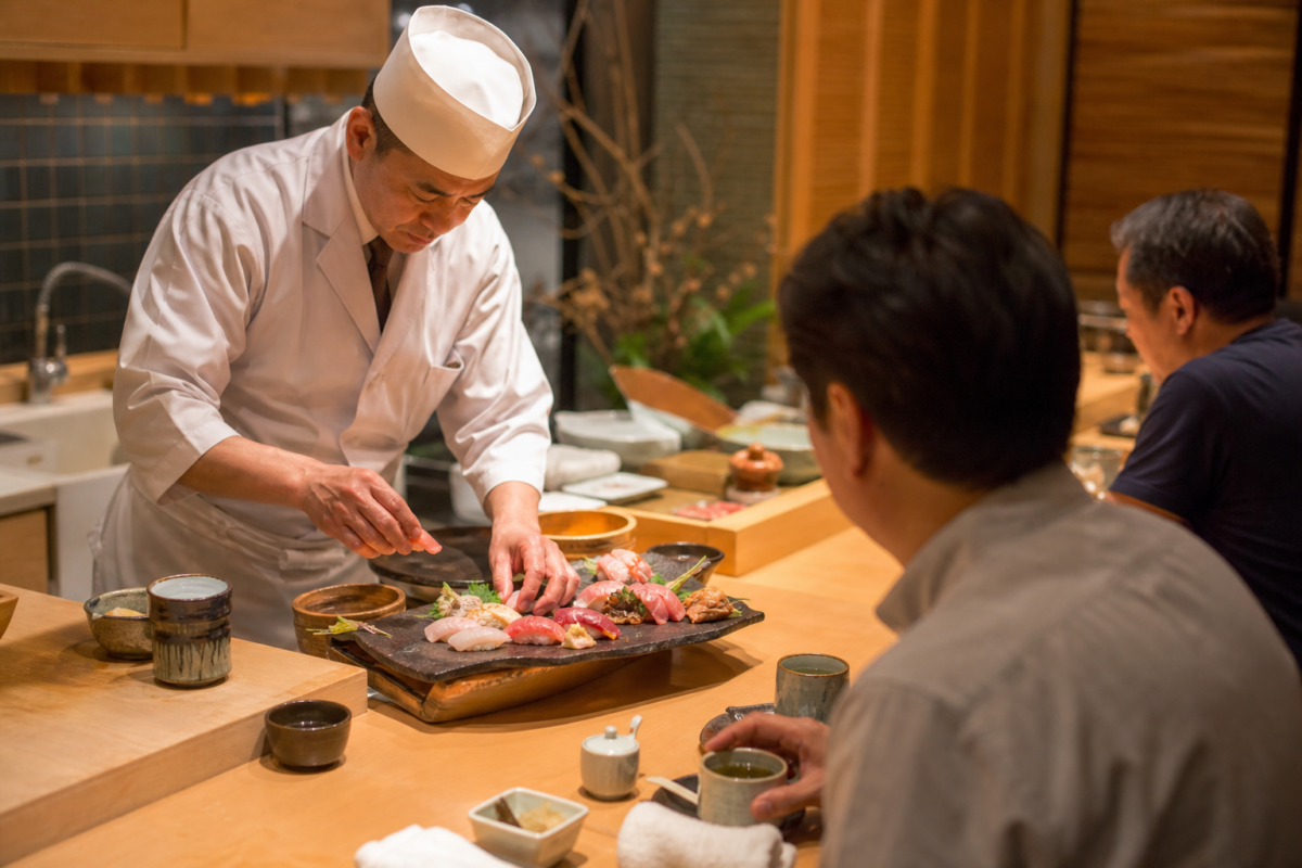 Japanese chef preparing sushi at a wooden Tokyo restaurant counter